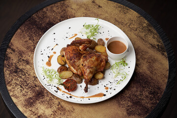 Grilled chicken Tabaka with baked potatoes and with sauce