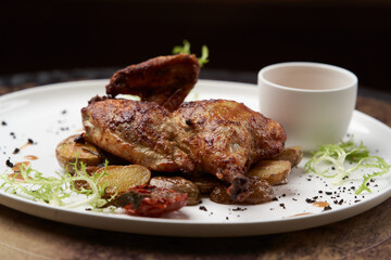 Grilled chicken Tabaka with baked potatoes and with sauce