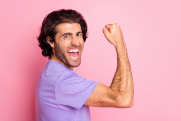 Fototapeta premium Photo of crazy bearded guy raise arm fist show muscle open mouth wear violet shirt isolated pastel pink color background