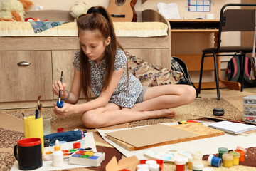 girl draws at home, artistic creation, makes creative artwork from paper, paints and brushes