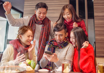 excited friends celebrating good news watching smart phone in the restaurant