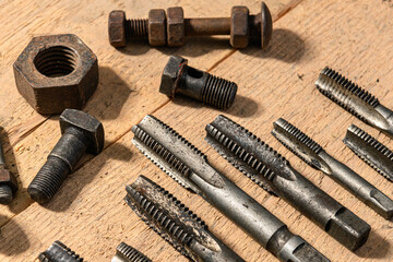 Old vintage hand tools - drills and threading die on a wooden background