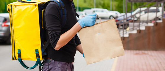 delivery boy of food delivery service walking down the street