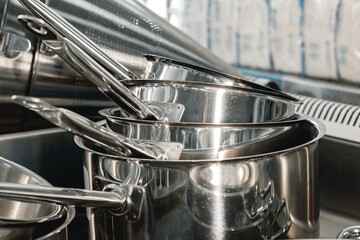 Stacked industrial metal cooking pots on proffesional kitchen