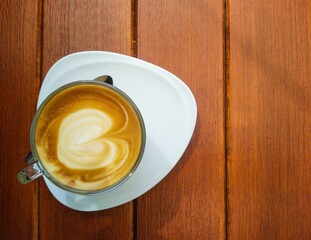 Hot coffee latte from top view with space on wooden table background, energy drink, coffee break or coffee shop