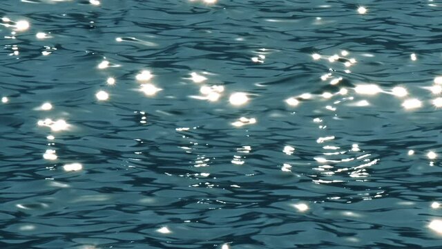 Slow motion of blue sea water surface with sparks