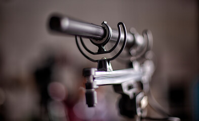 Shotgun microphone. Condenser hypercardioid mic mounted on stand with cable attached. Macro shot .