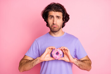 Photo of upset young man hold donut tow hands on diet unhealthy food isolated on pink color background