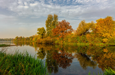 Fototapeta na wymiar The lake is surrounded by beautiful autumn trees.