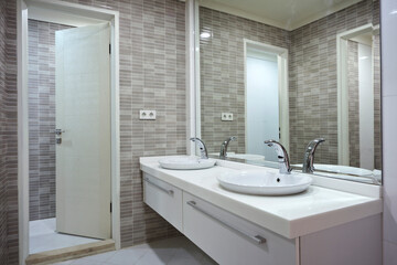 Fototapeta na wymiar Modern bathroom with electronic faucet and modern tiles