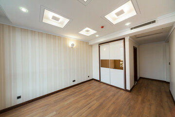 Empty room with wardrobe, window, parquet and wallpaper