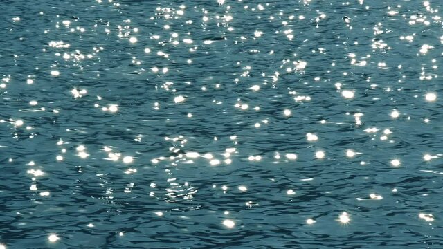 Slow motion of blue sea water surface with sparks