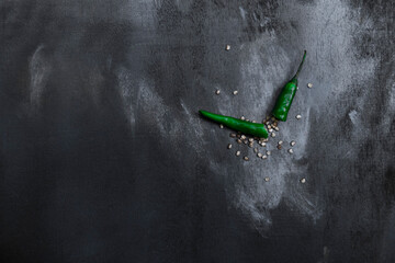 green chili broken from the meddle and seeds are spread all over the wooden table  