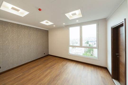 Empty room with window, parquet and wallpaper