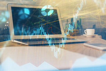Forex market chart hologram and personal computer background. Double exposure. Concept of investment.