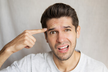 Portrait of a young gorgeous man with a crazy face expression asking are you stupid or not