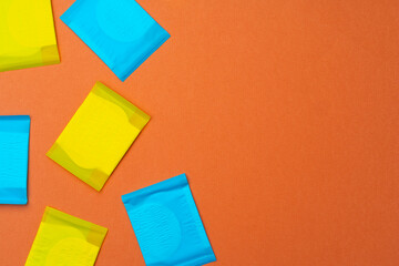 Woman hygienic pads on orange background top view