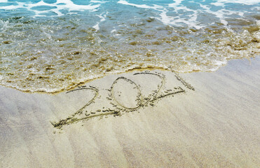 Happy New Year 2021 text on the beach