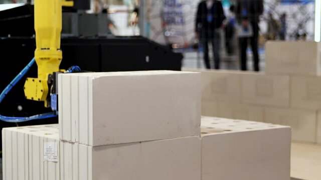 Automatic bricklayer robot working for building a wall. Media. Close up of automated machine presented at the robotic exhibition of technologies in construction industry.
