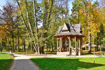 Wooden structure gazebo in a spa park. Relaxing place with a pavilion with bench. Full of autumn...