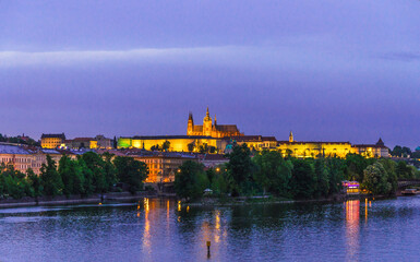 Obraz premium View of Prague old town, historical center with Prague Castle, St. Vitus Cathedral in Hradcany district, Vltava river, night evening twilight view, Bohemia, Czech Republic