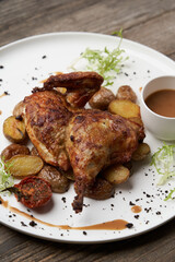 Grilled chicken Tabaka with baked potatoes and with sauce