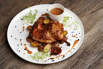 Grilled chicken Tabaka with baked potatoes and with sauce