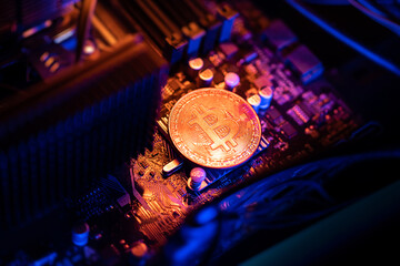 Bitcoin Cryptocurrency coin on a PC computer motherboard, crypto currency mining concept.