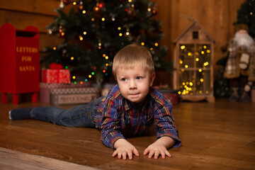 Cute little boy near tree decorated for Christmas. Merry Christmas and Happy New Year.