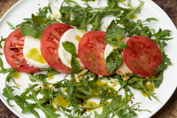 Italian caprese salad with sliced tomatoes, mozzarella