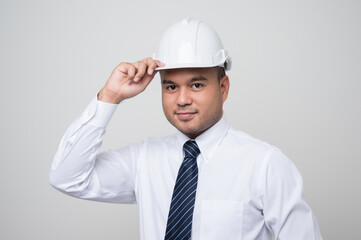 Smiling young handsome asian civil engineer standing on isolated white background. Manager senior mechanic in studio.