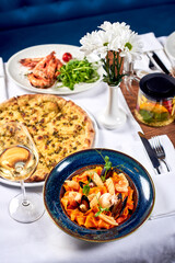 Pasta, pizza and fried shrimp on a table.