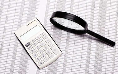 Magnifier, reports and white calculator lie on the desktop