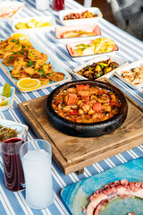 Seafoods, grilled meat, meze, herbs, fish, raki, ouzo, appetizers and salads in Greek or Turkish Fish Restaurant on the table for dinner or lunch at the beach from Greece or Turkey.