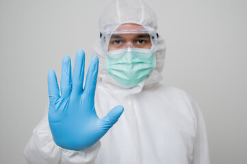 Close up A portrait of virologist put on PPE suit gesturing stop with hand.isolated on white background. Personal Protective Equipment Concept.