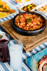 Seafoods, grilled meat, meze, herbs, fish, raki, ouzo, appetizers and salads in Greek or Turkish Fish Restaurant on the table for dinner or lunch at the beach from Greece or Turkey.