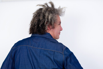 The back view of Handsome middle aged Caucasian man with afro gray hair, against white wall,  Studio Shoot.