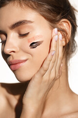 Beauty and skin care concept. Close-up of female model with clean no makeup face, applying facial...
