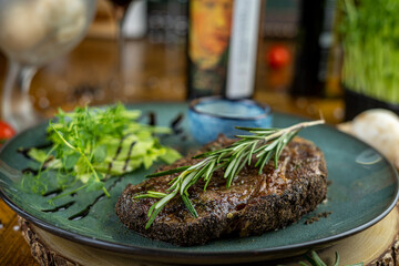 Pepper beef steak with rosemary and greens