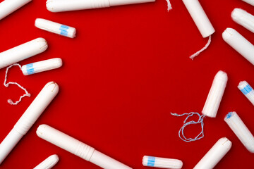 Pile of female tampons on red background - obrazy, fototapety, plakaty
