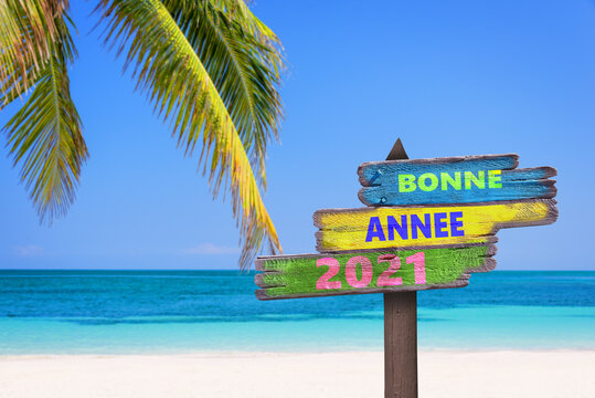 Bonne annee 2021, meaning happy new year in French, on direction signs, tropical beach background