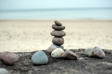 Fototapeta na wymiar Feng Shui. Pyramid of round stones on the beach.
