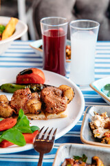 Grilled meat, seafoods, meze, herbs, fish, raki, ouzo, appetizers and salads in Greek or Turkish Restaurant on the table for dinner or lunch at the beach from Greece or Turkey.