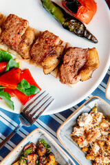 Grilled meat, seafoods, meze, herbs, fish, raki, ouzo, appetizers and salads in Greek or Turkish Restaurant on the table for dinner or lunch at the beach from Greece or Turkey.