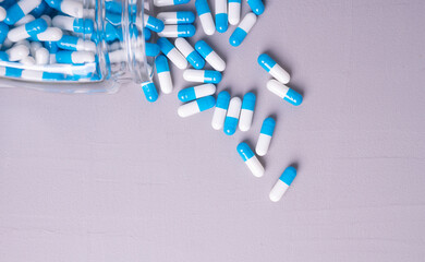 white and blue pills on a gray background. medical background