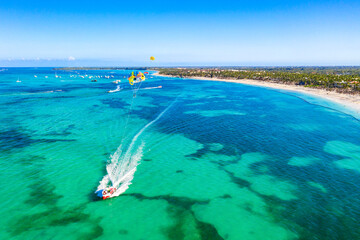 Tourists parasailing near Bavaro Beach, Punta Cana in Dominican Republic. Aerial view of tropical...