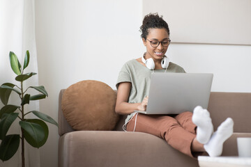 Young woman using laptop computer at home. Student girl working in her room. Work or study from...