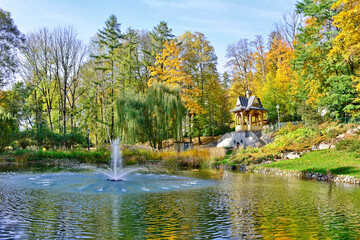 ity park at autumn with mini waterfall, pond and arbor in the blurred background, Szczawnica, Poland