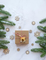 Fototapeta na wymiar Christmas and New Year holiday concept. Gift box, deer toy, snowflakes and fir tree. winte season. flat lay. copy space