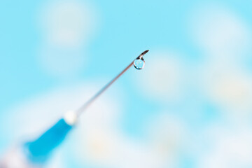 close up. drop of medicine on the needle of a syringe.